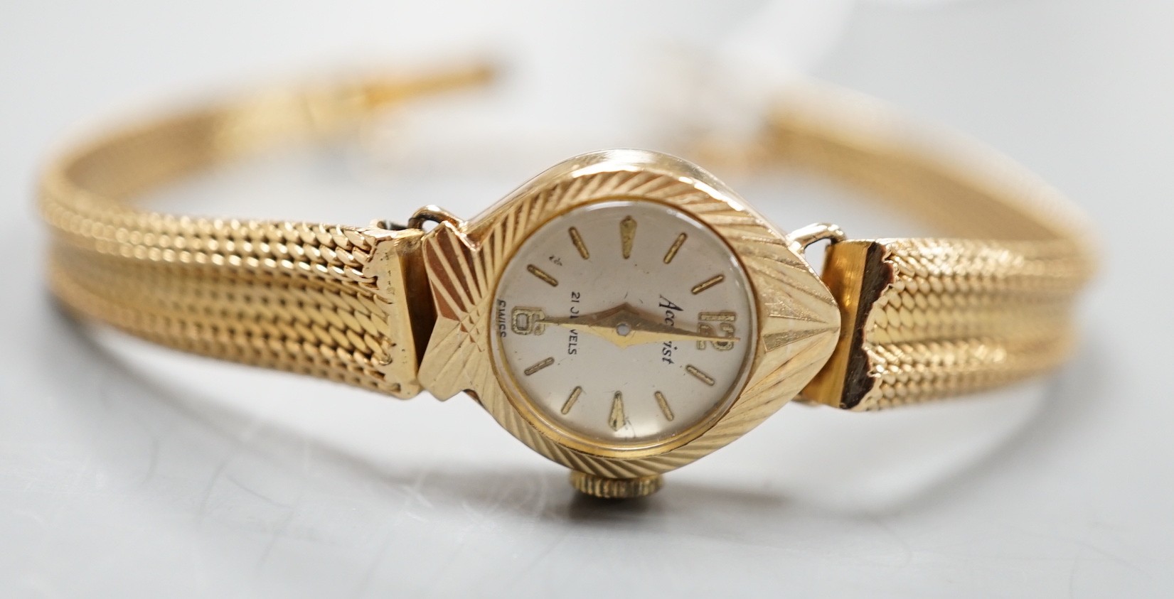 A lady's 9ct gold Accurist manual wind wrist watch, on a continental yellow metal bracelet, gross weight 21.2 grams.